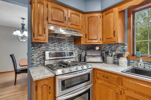 a kitchen with stainless steel appliances granite countertop a stove a sink and a microwave