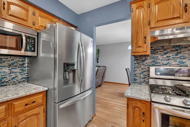 a kitchen with stainless steel appliances granite countertop a refrigerator and a stove