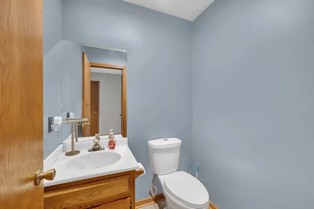 a bathroom with a sink mirror vanity and toilet