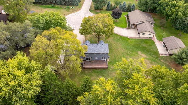 an aerial view of a house with a yard swimming pool and outdoor seating