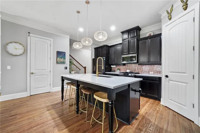 a kitchen with stainless steel appliances granite countertop a sink a stove and a refrigerator