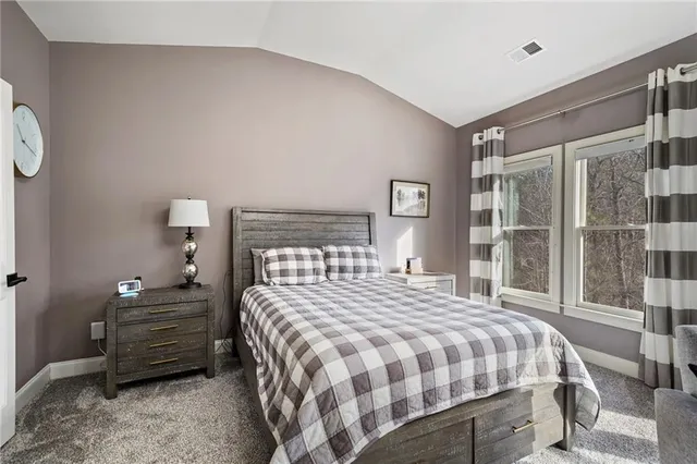 a bedroom with a bed a lamp and window