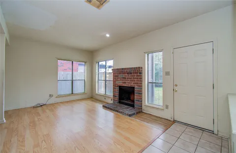 a view of an empty room with a fireplace and a window