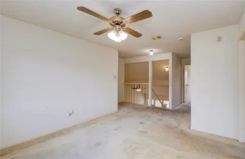 an empty room with fan and windows