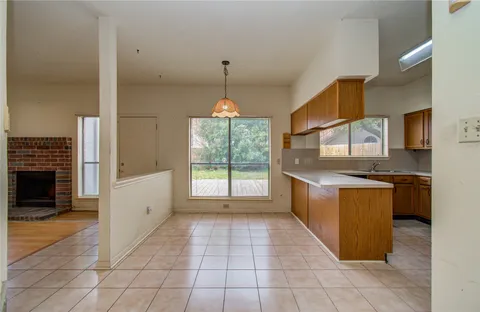 a view of a hallway with wooden floor and chandelier