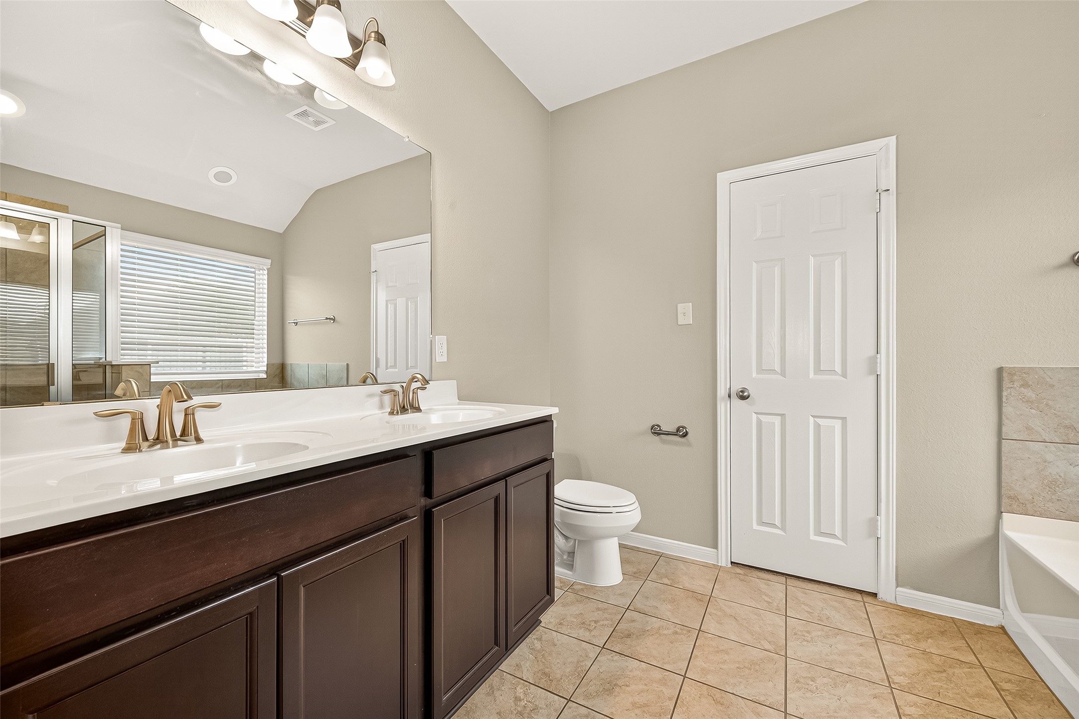 7219 Victorville Drive Rosharon, TX 77583 - Photo 25 of 34 a bathroom with a double vanity sink a toilet and a mirror