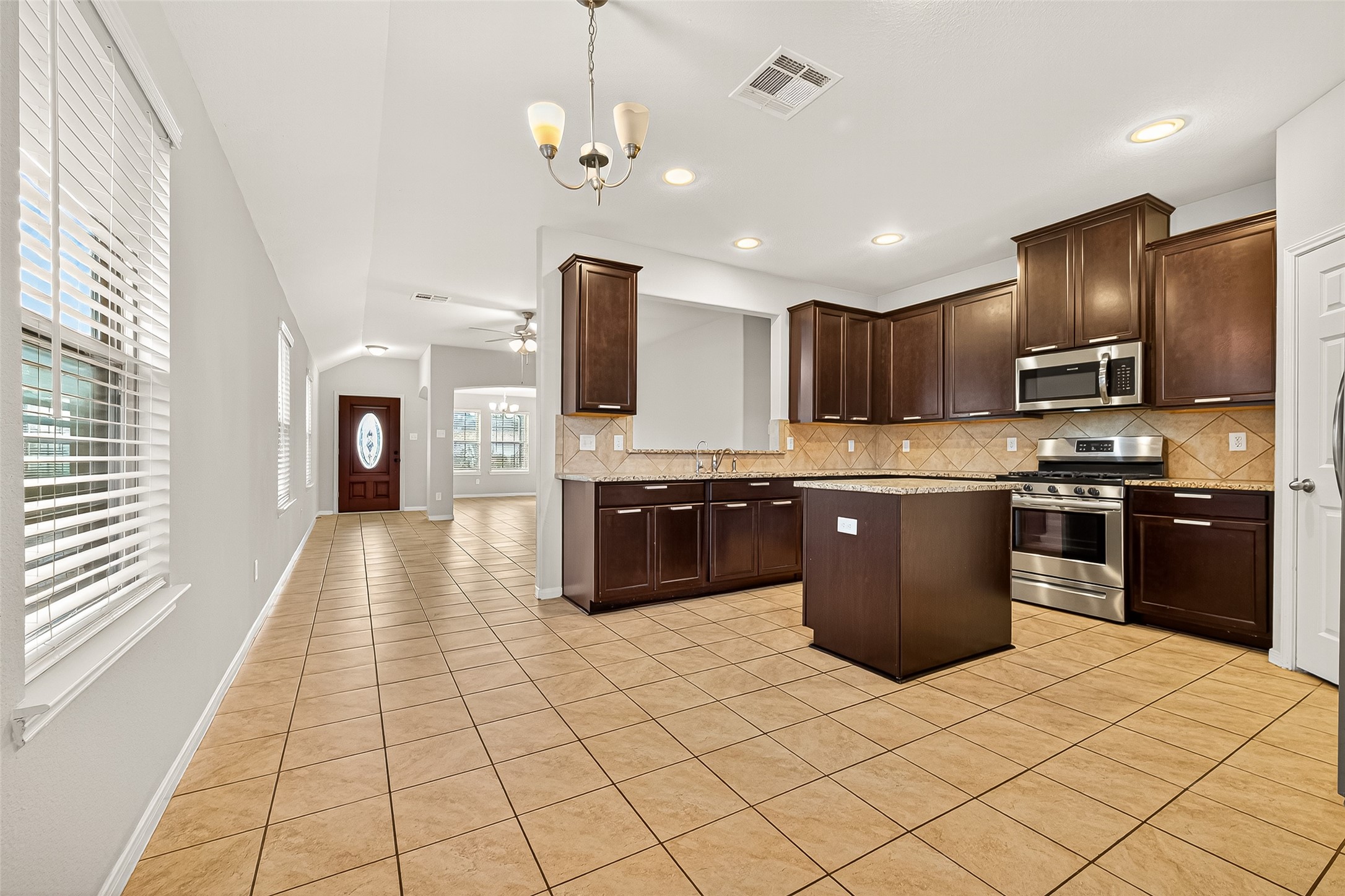 7219 Victorville Drive Rosharon, TX 77583 - Photo 10 of 34 a large kitchen with stainless steel appliances granite countertop a stove top oven a sink dishwasher a refrigerator and a cabinets