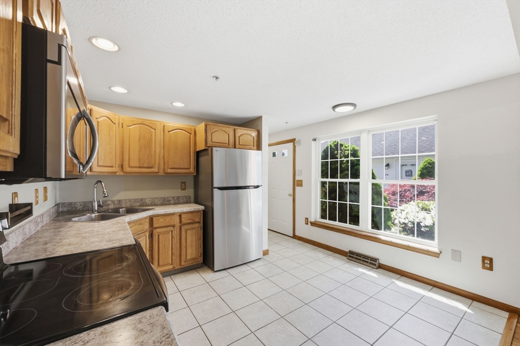 18 Castle Hills Road, Unit G Agawam, MA 01001 - Photo 7 of 39 a kitchen with granite countertop a refrigerator and a sink