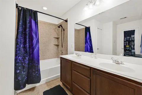 a bathroom with a bathtub sink vanity and shower