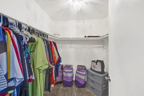 a view of walk in closet with clothes and shoes