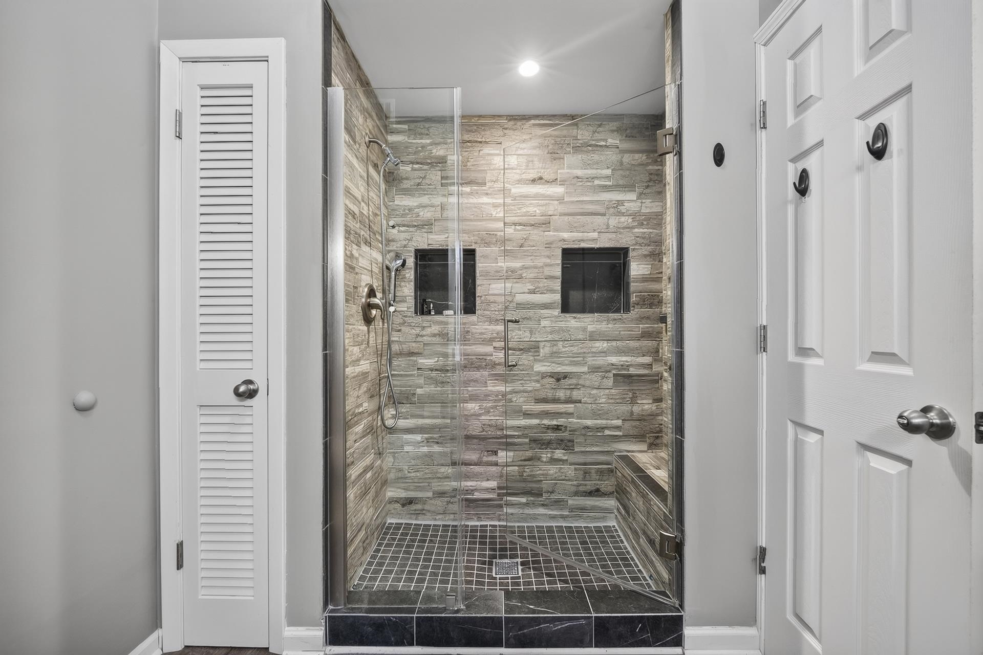 74 Driftwood Road Counce, TN 38326 - Photo 27 of 40 Glass-enclosed shower featuring stacked stone-look wall tile and a built-in bench