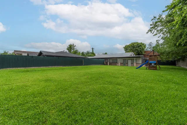 a view of a green field with wooden fence