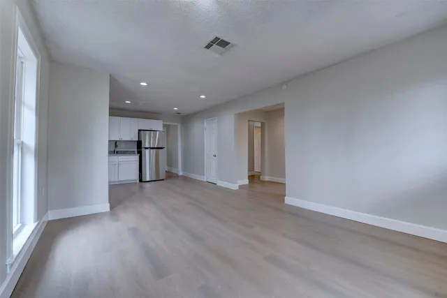a view of empty room with a kitchen