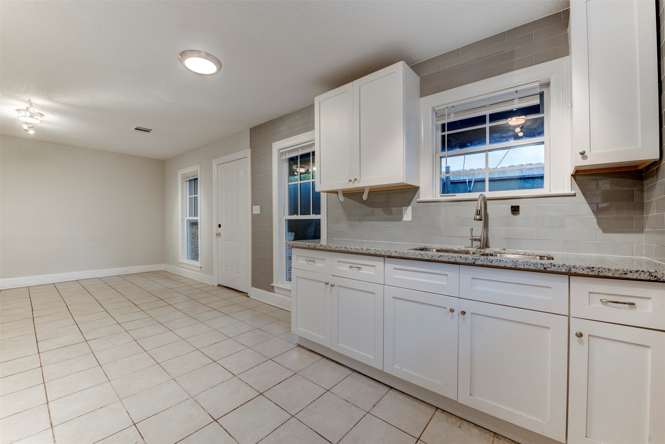 2127 Maximilian Street, Unit 10 Houston, TX 77039 - Photo 9 of 11 a kitchen with granite countertop white cabinets and sink