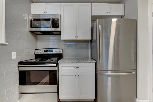 a kitchen with stainless steel appliances white cabinets and a stove