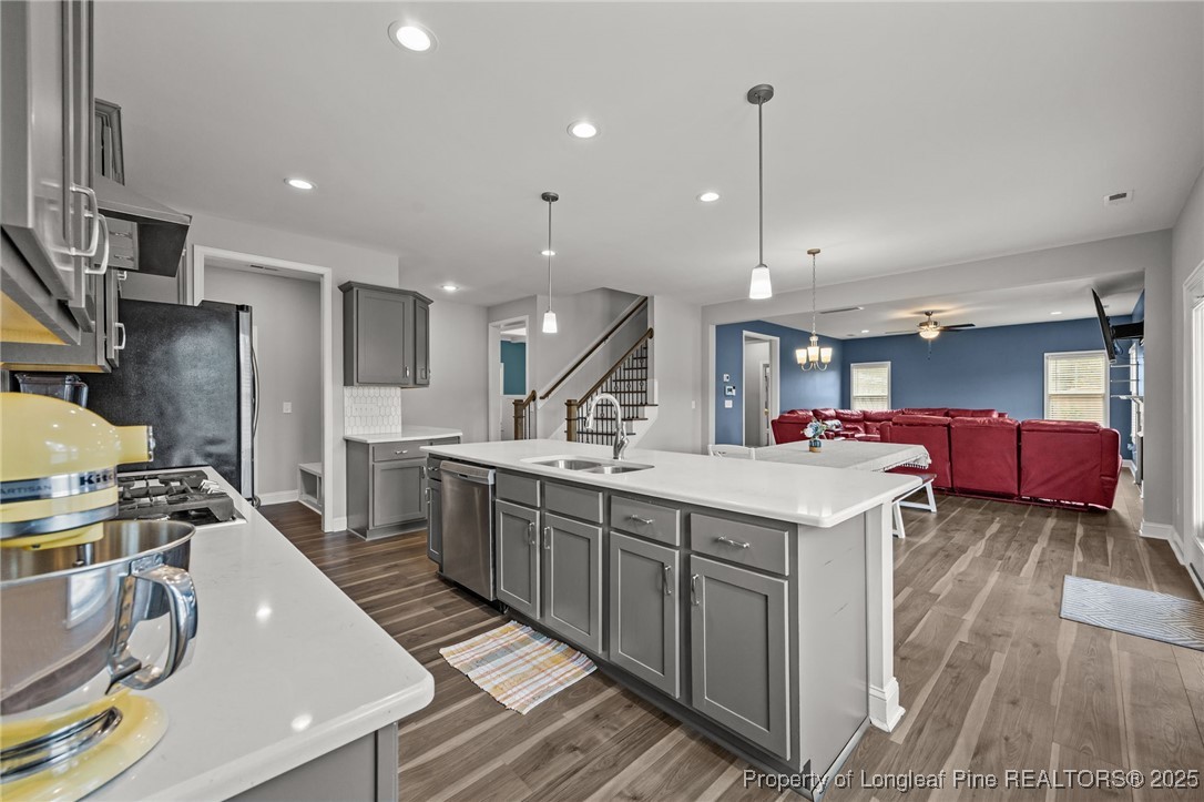 3079 Wade-Stedman Road Stedman, NC 28391 - Photo 14 of 50 a kitchen with stainless steel appliances granite countertop a sink a stove and a wooden floors