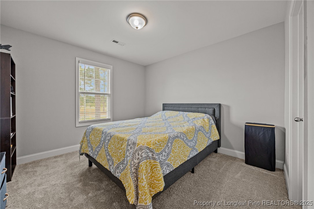 3079 Wade-Stedman Road Stedman, NC 28391 - Photo 39 of 50 a bed sitting in a bedroom next to a window