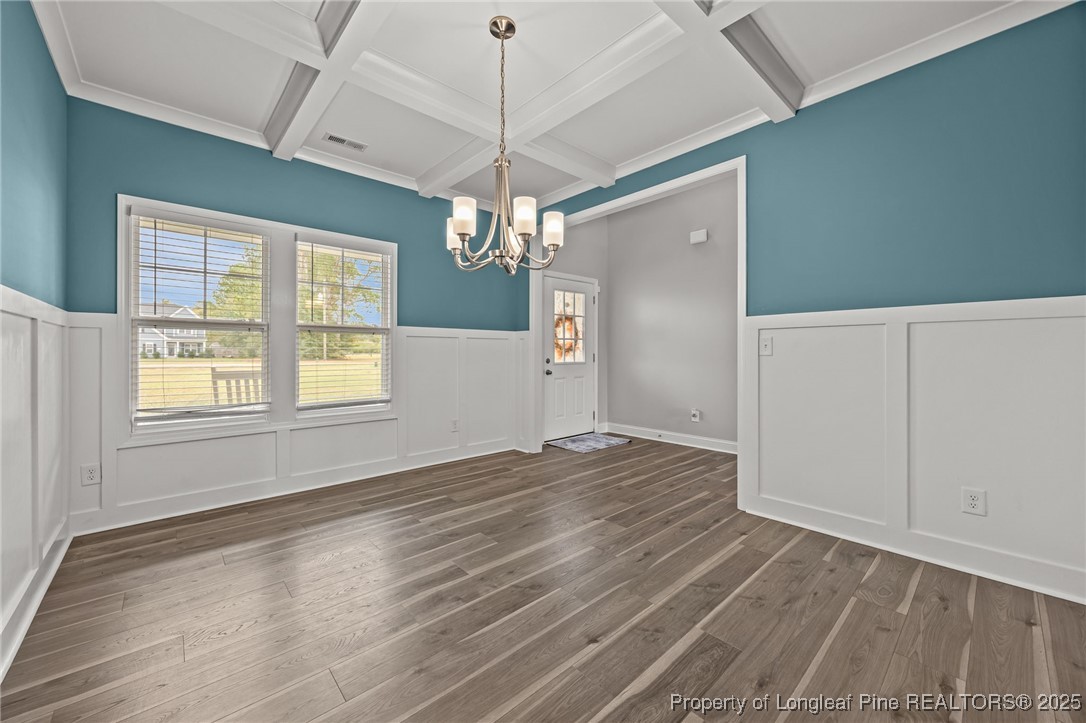 3079 Wade-Stedman Road Stedman, NC 28391 - Photo 7 of 50 an empty room with wooden floor chandelier fan and windows