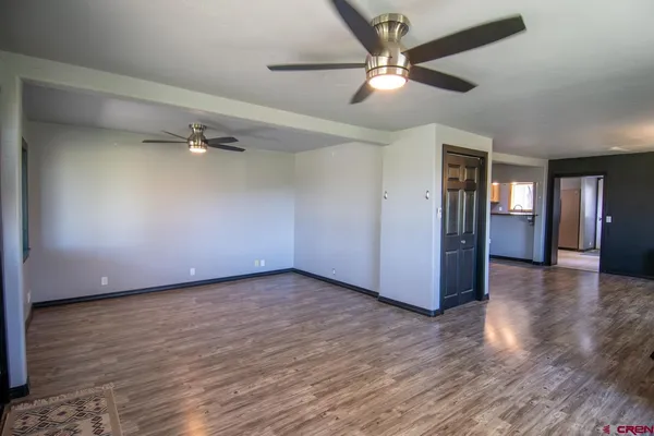 a view of an empty room with a window and wooden floor