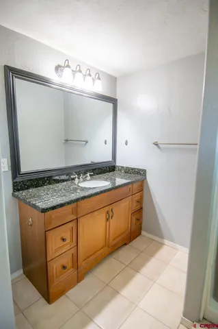 a bathroom with a granite countertop sink and a mirror