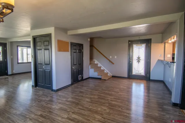 a view of a hallway with wooden floor and stairs