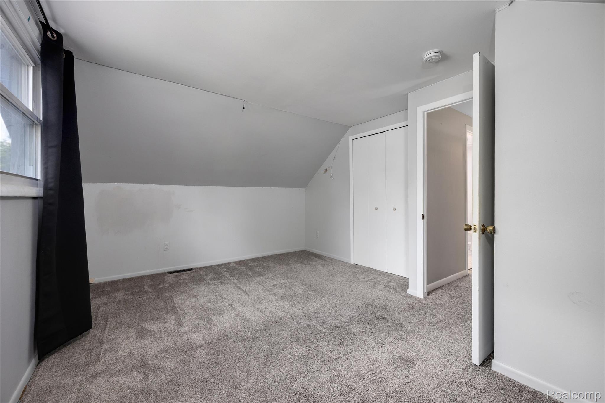 4942 Butler Drive Troy, MI 48085 - Photo 24 of 33 Carpeted room featuring a sloped ceiling, double bi-fold closet, and a white interior door with brass hardware