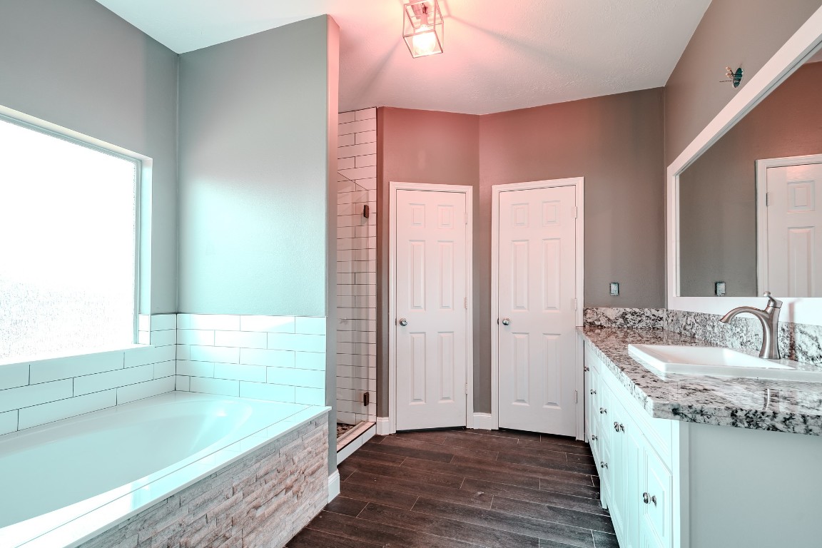 8515 Holly Spring Lane Baytown, TX 77523 - Photo 17 of 28 Primary en suite bathroom, recently remodeled with a new tub, vanity, counters, mirrors and shower.