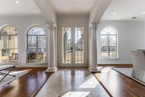 a view of a room with large windows and wooden floor