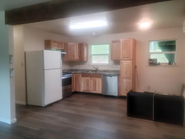 a kitchen with stainless steel appliances white cabinets and wooden floor