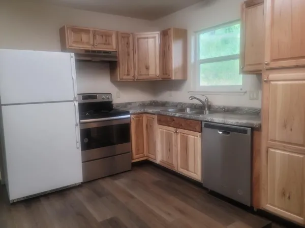 a kitchen with granite countertop white cabinets and white appliances