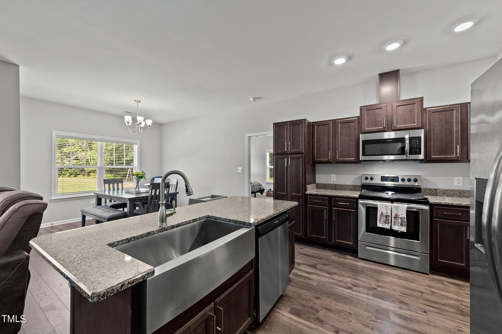 7588 Sadie Road Kenly, NC 27542 - Photo 29 of 58 a kitchen with stainless steel appliances granite countertop a sink stove and refrigerator
