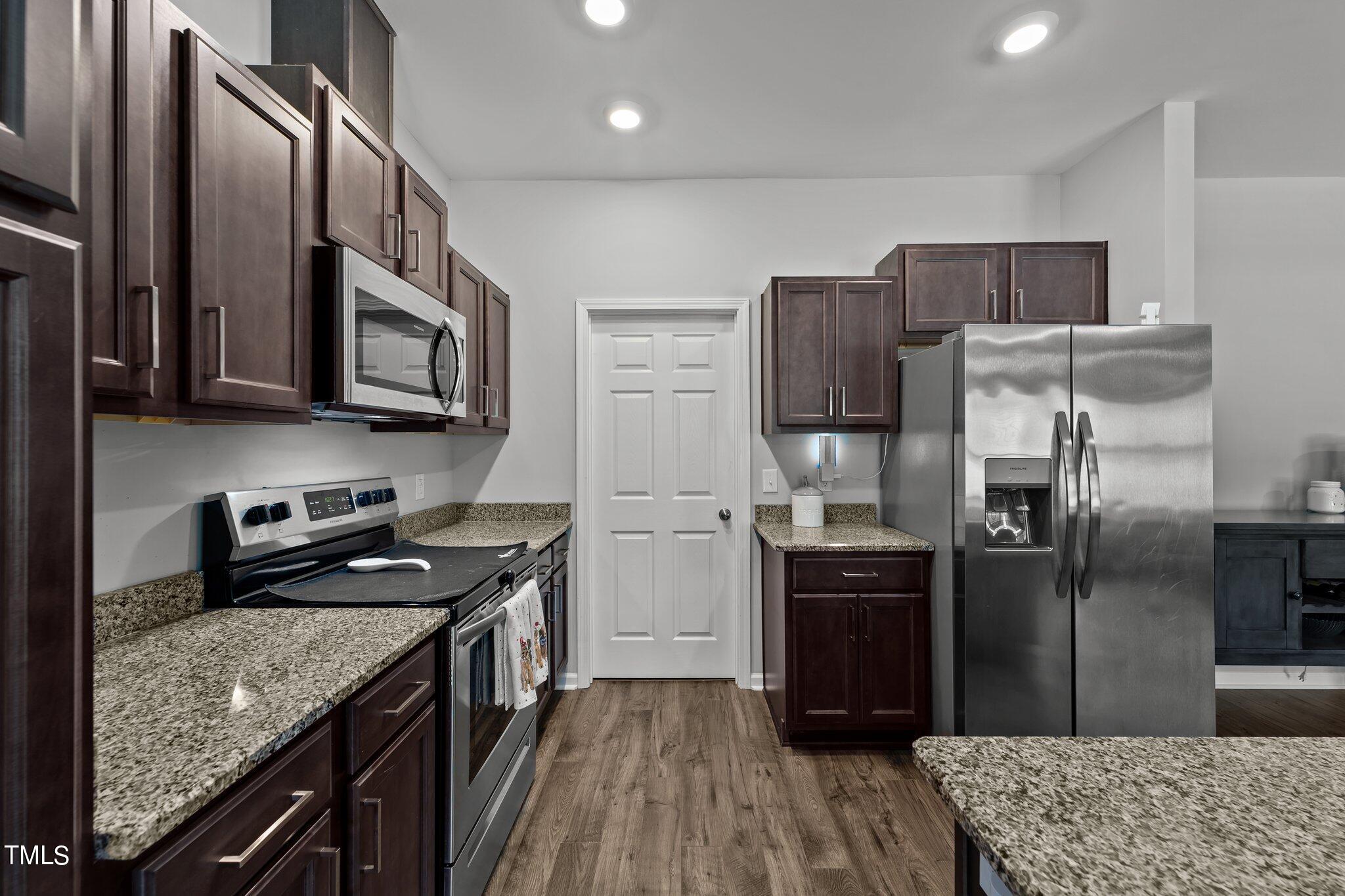 7588 Sadie Road Kenly, NC 27542 - Photo 33 of 58 a kitchen with stainless steel appliances granite countertop a refrigerator a stove and a sink