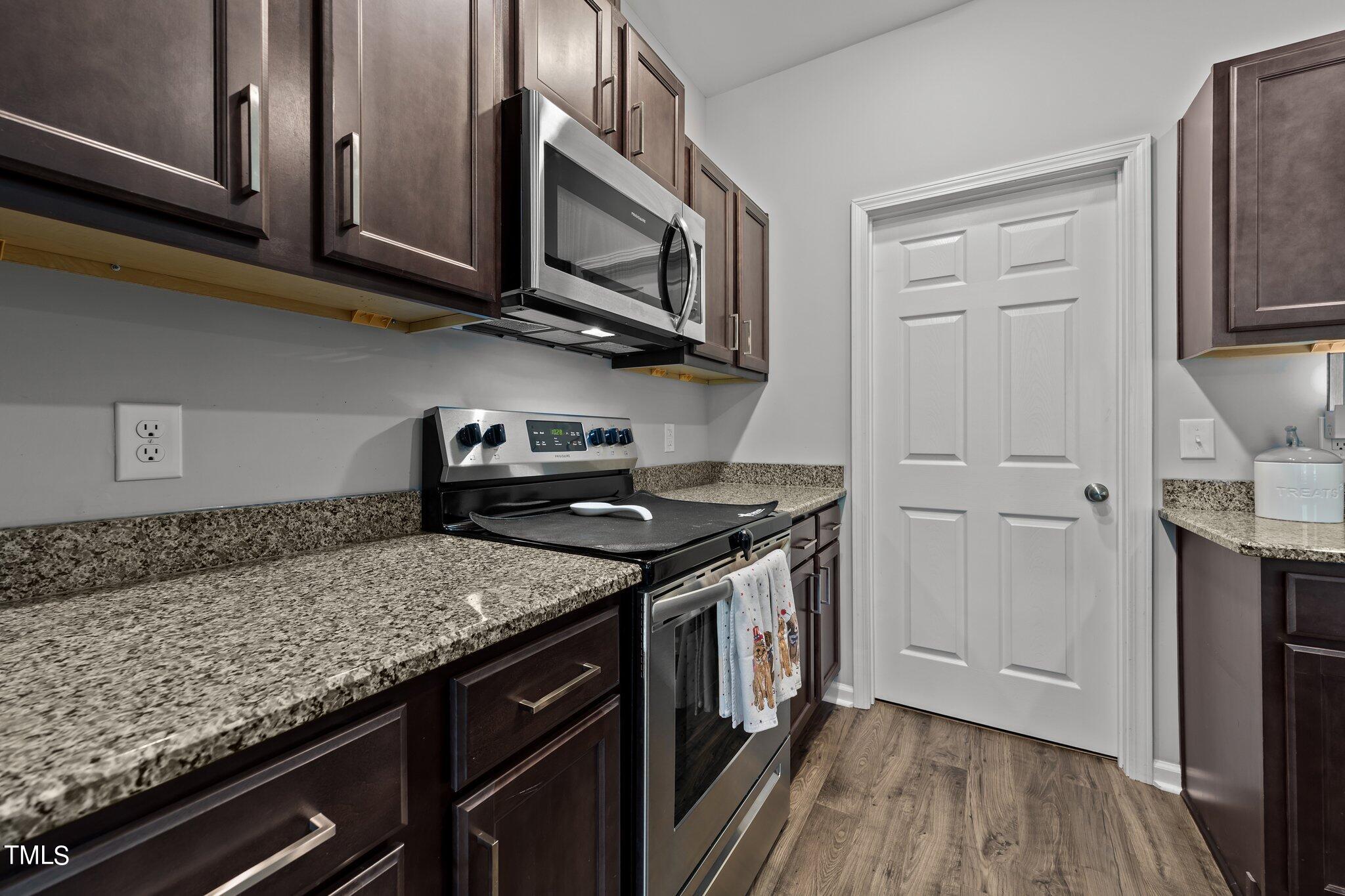 7588 Sadie Road Kenly, NC 27542 - Photo 35 of 58 a kitchen with stainless steel appliances granite countertop a stove and a microwave