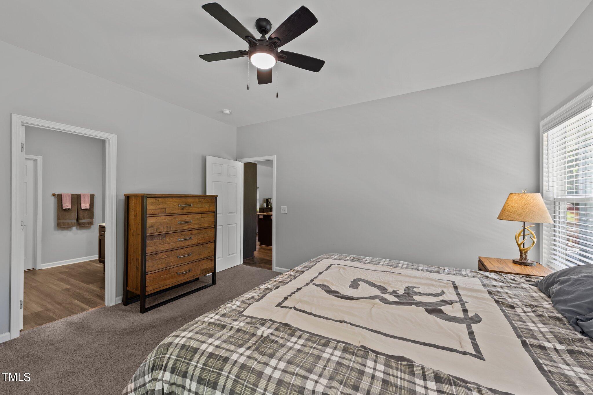 7588 Sadie Road Kenly, NC 27542 - Photo 41 of 58 a bedroom with a bed and a chandelier