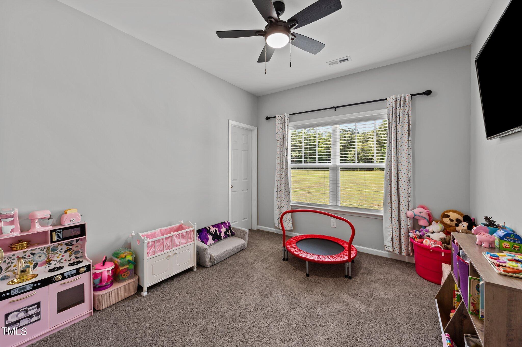 7588 Sadie Road Kenly, NC 27542 - Photo 44 of 58 a bedroom with a bed and a chandelier