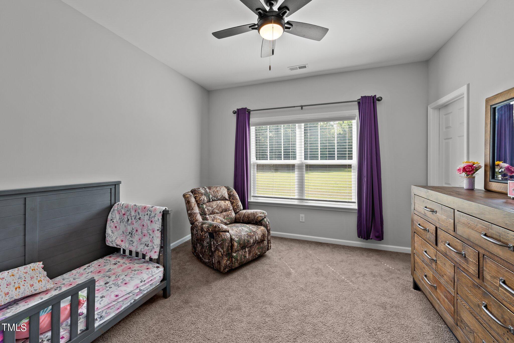 7588 Sadie Road Kenly, NC 27542 - Photo 46 of 58 a spacious bedroom with a bed and a chandelier