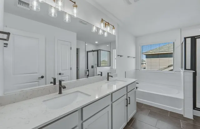 a bathroom with a sink a vanity a mirror and a bathtub