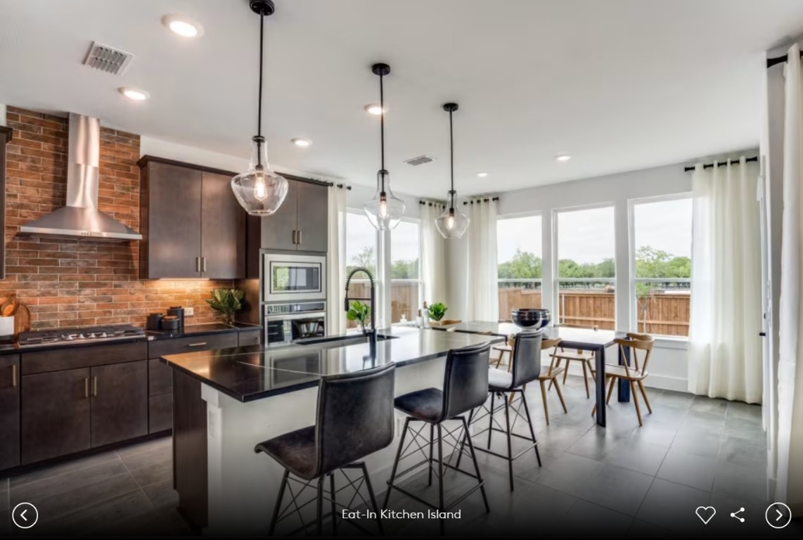 337 Foresail Road Leander, TX 78641 - Photo 7 of 12 a kitchen with stainless steel appliances granite countertop a stove a refrigerator a sink a dining table and chairs with wooden floor