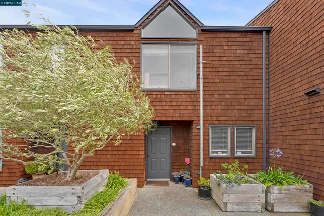 a brick house with a yard and table and chairs under an umbrella
