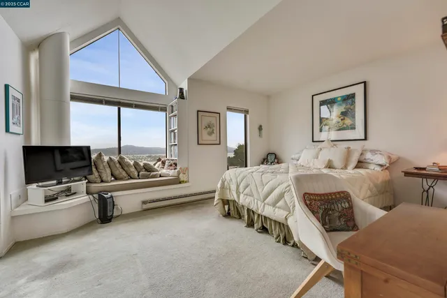 a bedroom with furniture and a large window