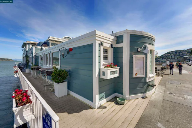 a view of a swimming pool with a table and chairs under an umbrella