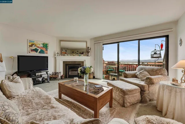 a living room with furniture large window and a fireplace