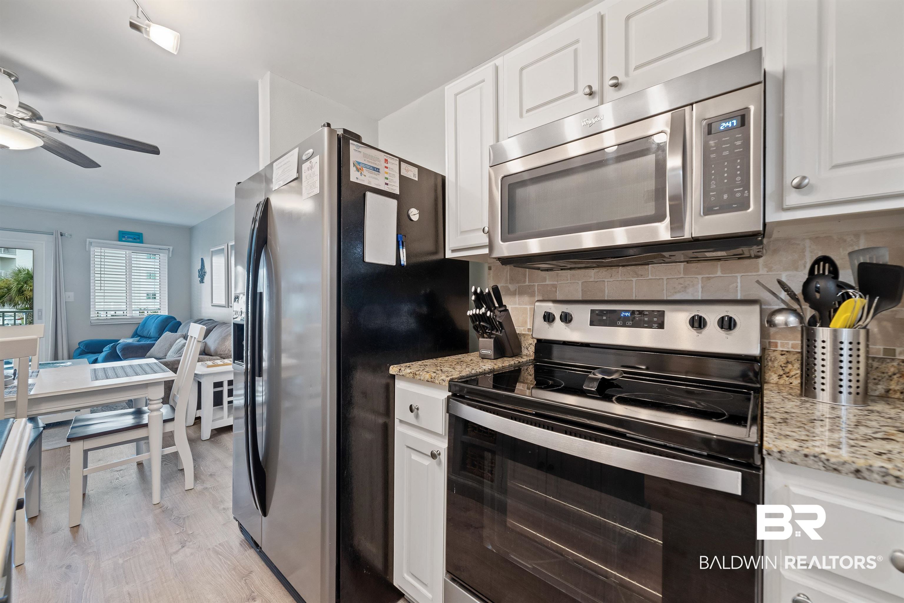400 Plantation Road, Unit 2123 Gulf Shores, AL 36542 - Photo 6 of 44 Kitchen with ceiling fan, white cabinets, light wood-type flooring, appliances with stainless steel finishes, and backsplash