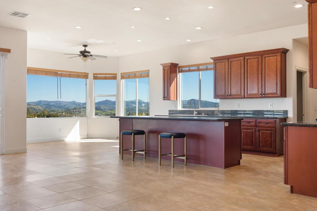 4261 Entrada Al Sol Bonsall, CA 92003 - Photo 11 of 49 a kitchen with stainless steel appliances granite countertop a stove a sink and a microwave