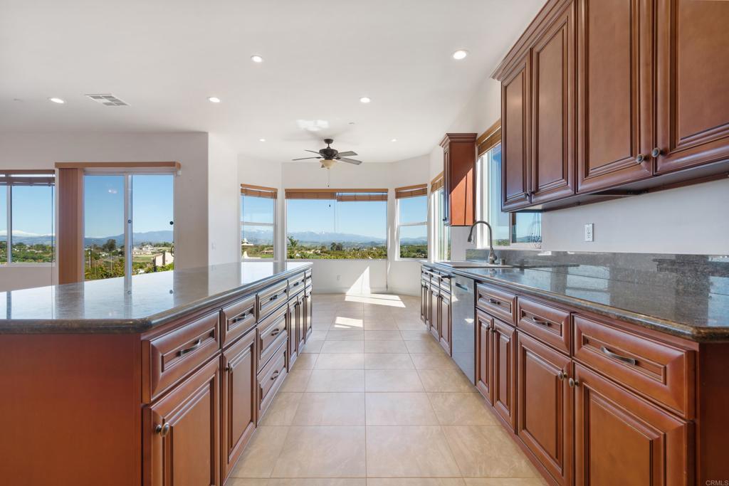 4261 Entrada Al Sol Bonsall, CA 92003 - Photo 13 of 49 a large kitchen with stainless steel appliances a sink and a large window