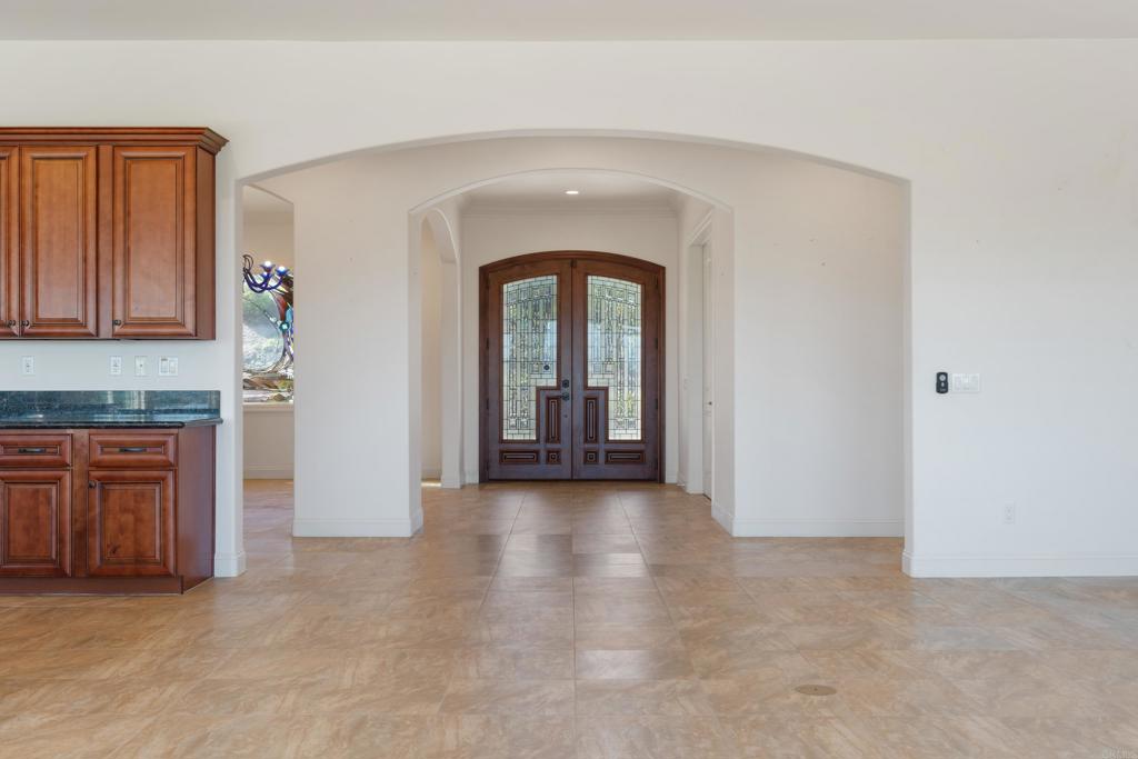 4261 Entrada Al Sol Bonsall, CA 92003 - Photo 19 of 49 an empty room with a fireplace and cabinet