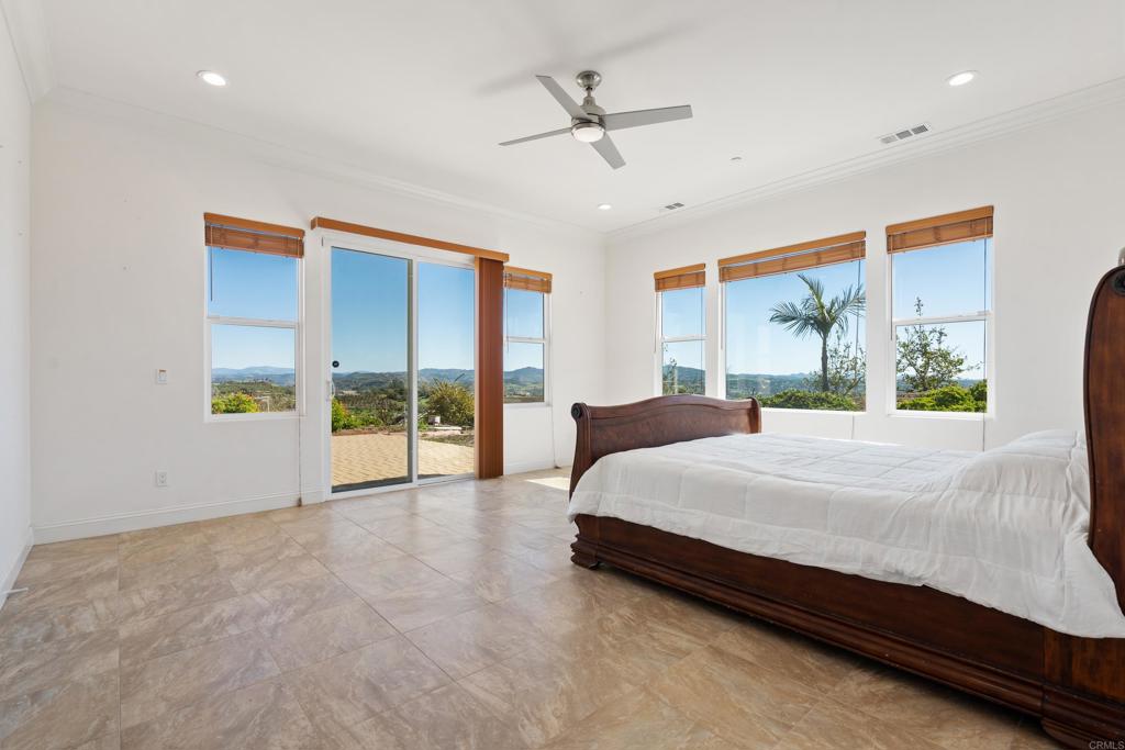 4261 Entrada Al Sol Bonsall, CA 92003 - Photo 21 of 49 a spacious bedroom with a large bed and a large window