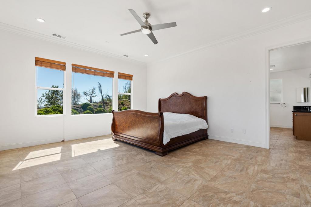4261 Entrada Al Sol Bonsall, CA 92003 - Photo 22 of 49 a bedroom with a bed lamp and window