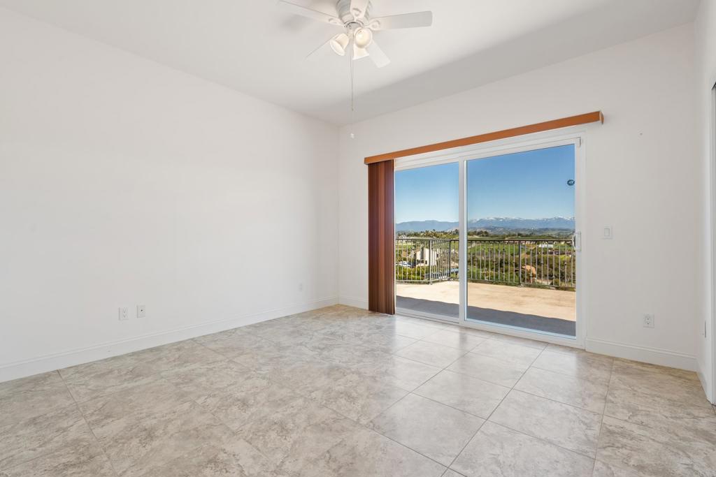 4261 Entrada Al Sol Bonsall, CA 92003 - Photo 34 of 49 an empty room with chandelier fan and windows