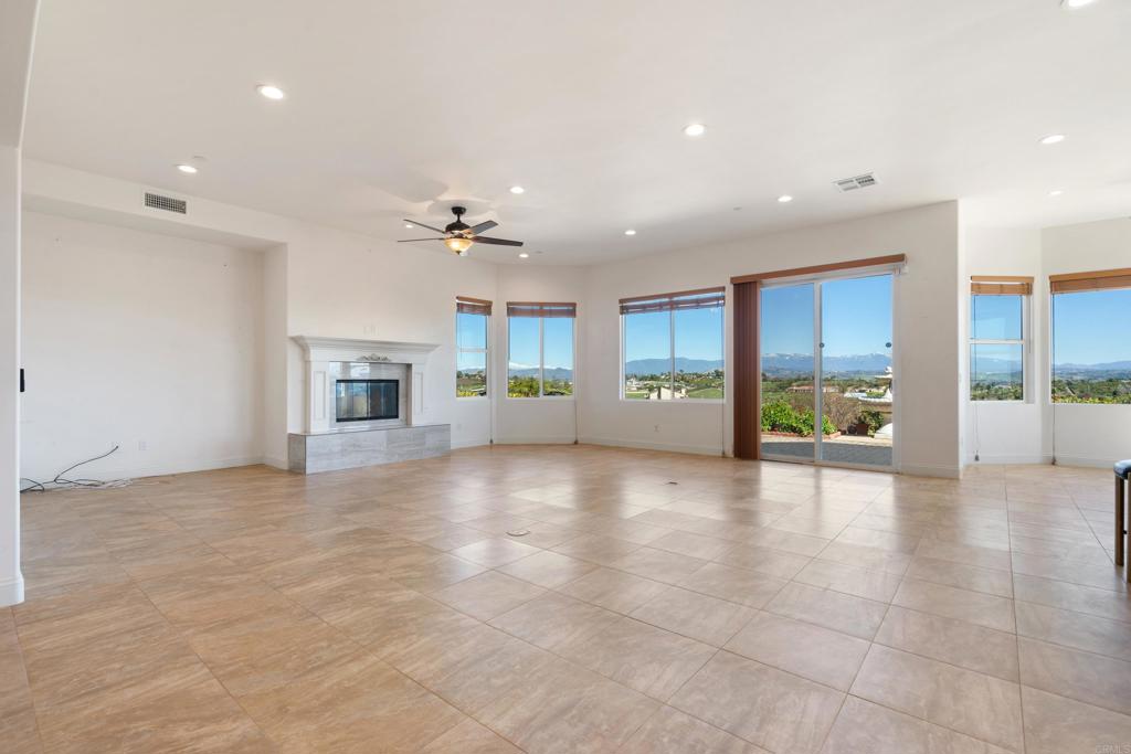 4261 Entrada Al Sol Bonsall, CA 92003 - Photo 7 of 49 a view of an empty room with a fireplace and a large window
